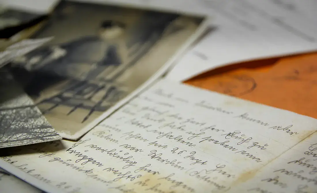 Old family letters and photographs laid out on a table